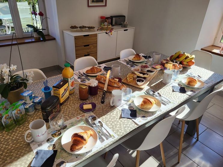 Table du petit-déjeuner maison au Clos d'Audio avec viennoiseries et confitures